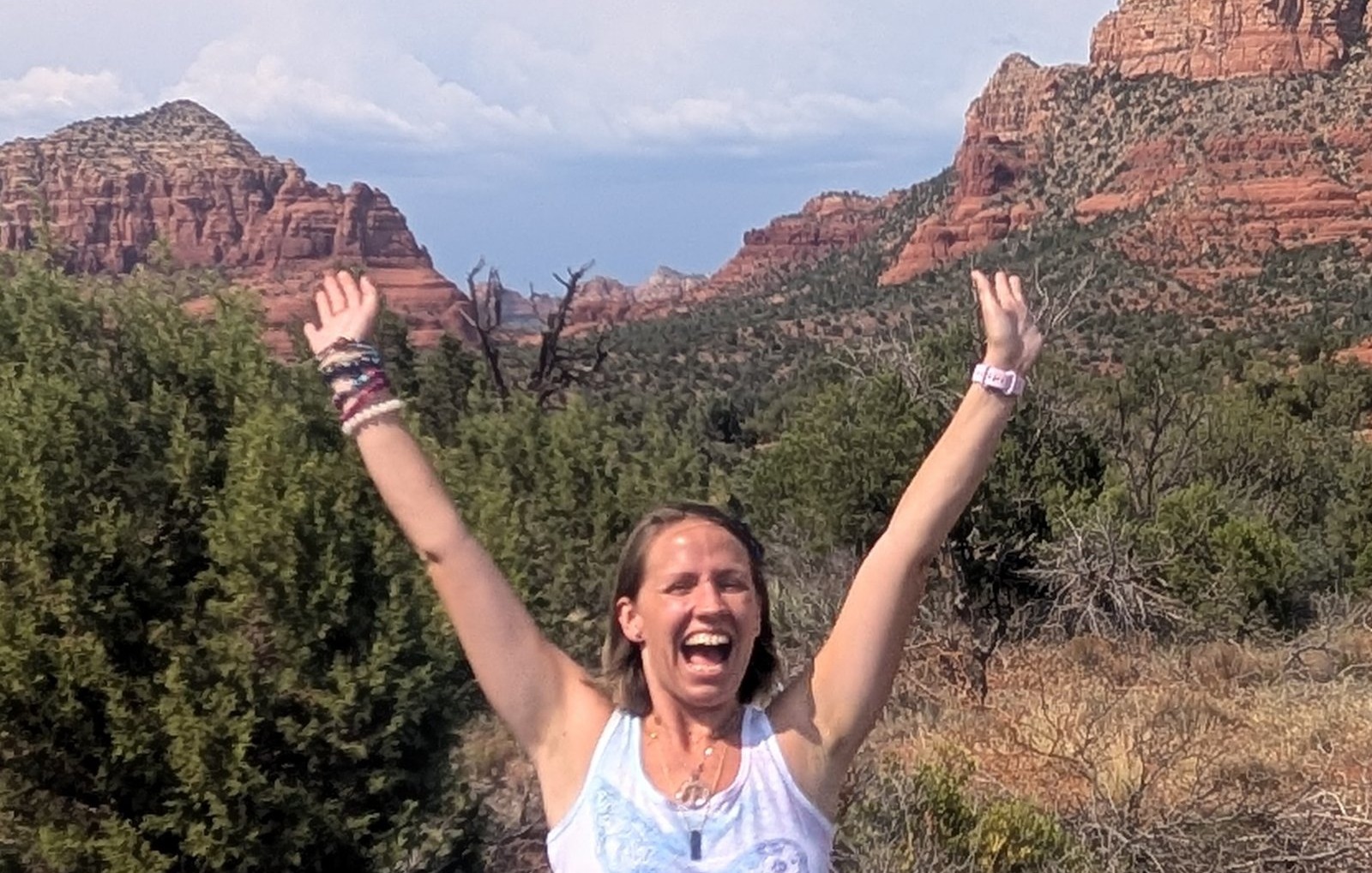 Julie Ann Kessler, The Chakra Fairie, arms raised among red rocks