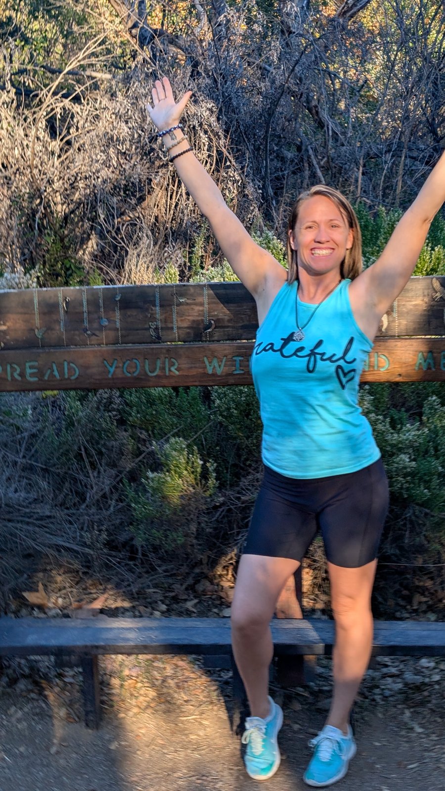 Julie Ann celebrating on a sunny trail